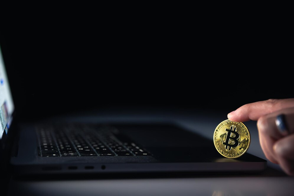 bitcoin-coin-near-laptop-black-background-finance-crypto-money-concept_169016-63549